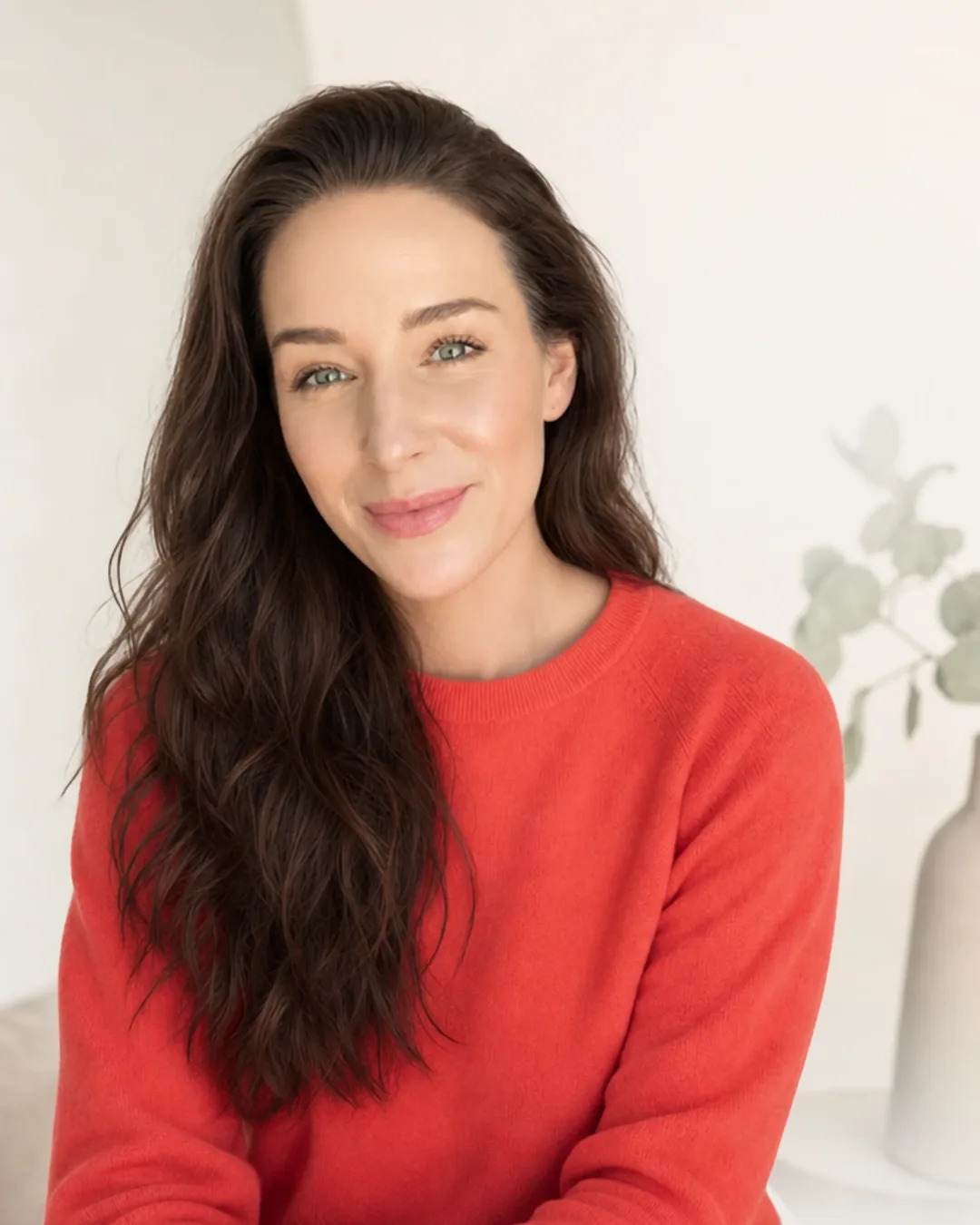 Petra Burger mit braunen Haaren in rotem Pullover, porträtfotografie vor weißem Hintergrund