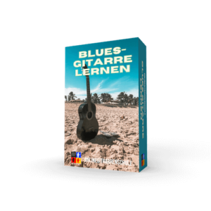 Blues-Gitarre lernen Produktbox mit schwarzer Akustikgitarre auf Strand