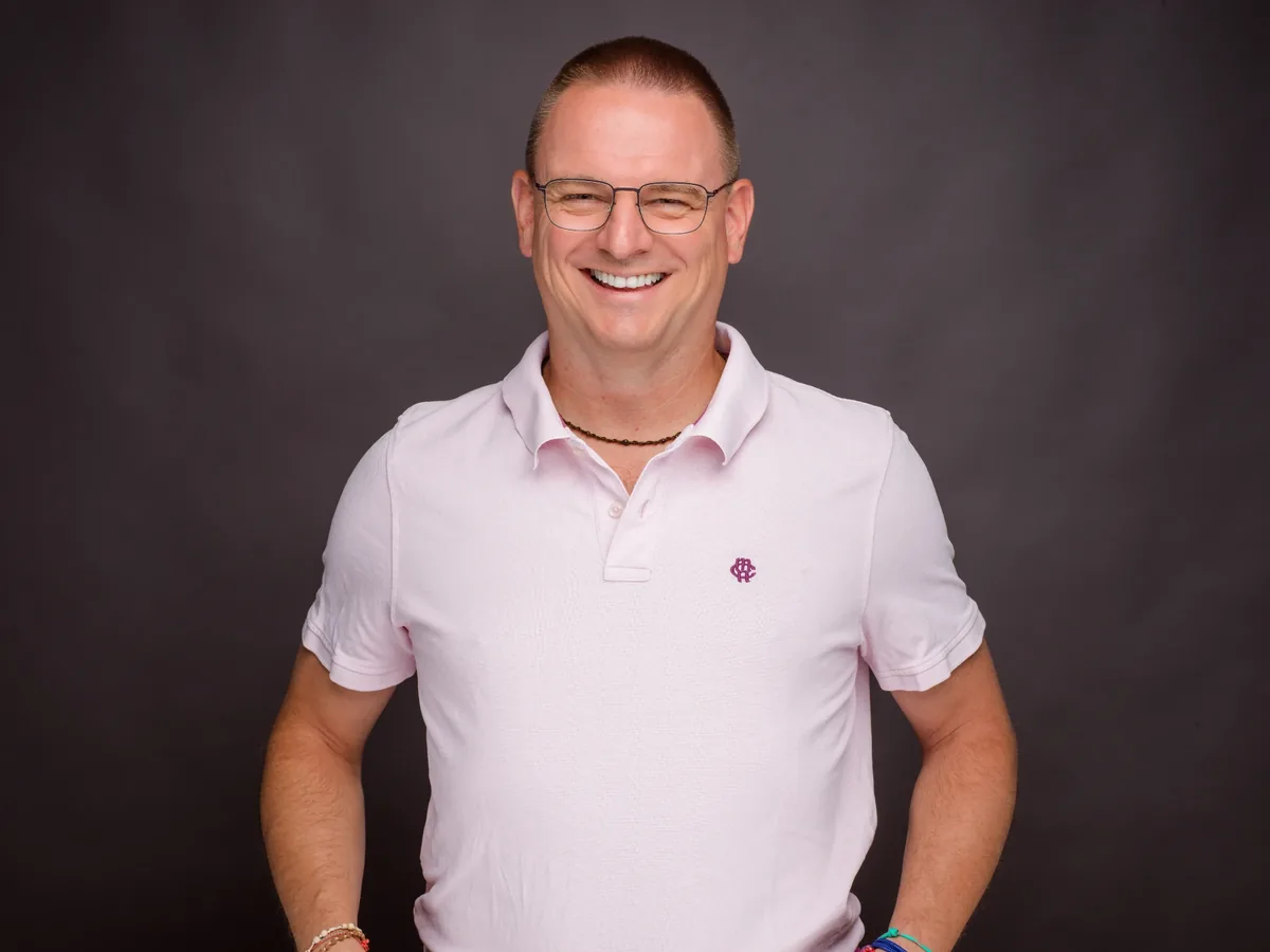 Markus Lehnert Portrait mit Brille, rosa Poloshirt, lächelnd
