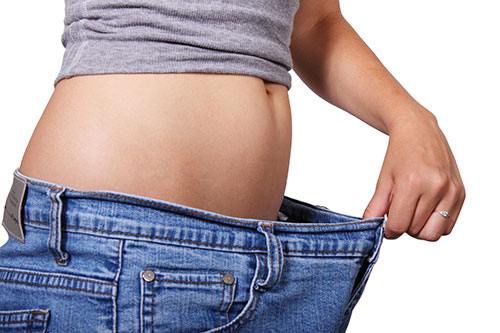 Bauch einer Person in Jeans, Gewichtsverlust und Diät