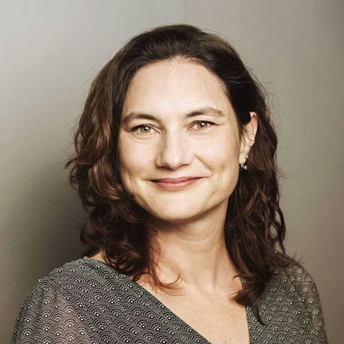 Porträtfoto von Susanne Möller, Frau mit braunem Haar vor neutralem Hintergrund