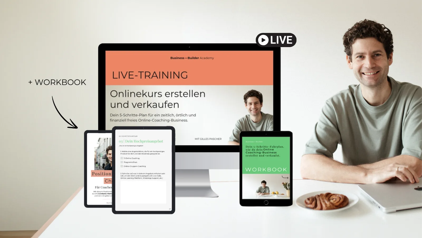 Mann sitzt am Tisch, dahinter Bildschirm mit Live-Training-Ankündigung und Tablets mit Workbook