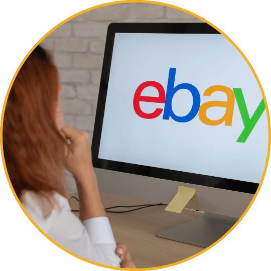Frau vor Monitor mit eBay Logo, Büroumgebung, kreisrund zugeschnitten mit orange Rand