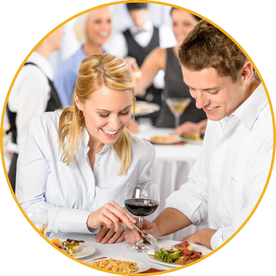 Zwei lächelnde Mitarbeiter beim professionellen Catering-Service mit Wein und Häppchen