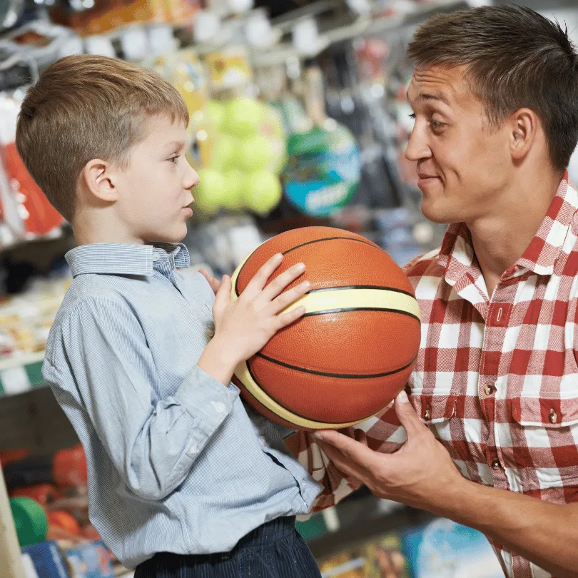 Verkäufer und Junge im Sportgeschäft mit Basketball, Beratungssituation