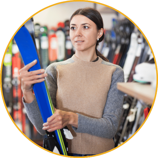 Sportverkäuferin mit Ski im Geschäft, Produktberatung mit orangem Rahmen