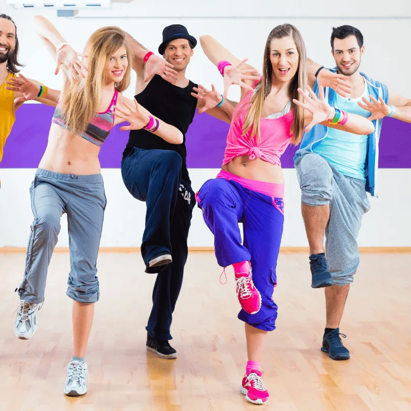 Tanzschule Gruppenkurs mit fünf jungen Erwachsenen in bunter Sportkleidung lächelnd