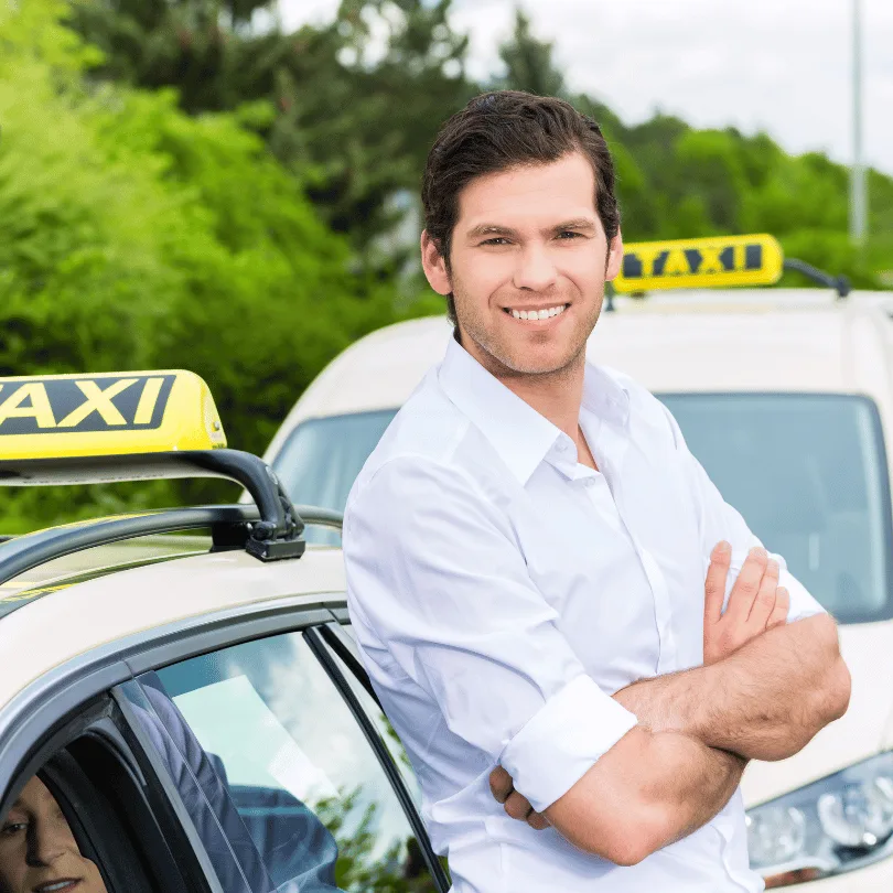 Businessplan Taxiunternehmer – Vorlage mit Finanzplan zur Gründung 3 Junger Mann in weißem Hemd lehnt lächelnd an Taxi mit gelbem Dachschild, grüner Hintergrund