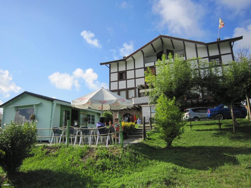 Guesthouse mit Fachwerk-Architektur, grüne Wiese und Sonnenschirm