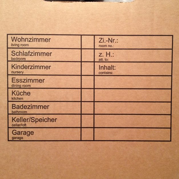 Umzugskarton mit deutschem Inventuretikett für Wohnzimmer, Schlafzimmer, Küche