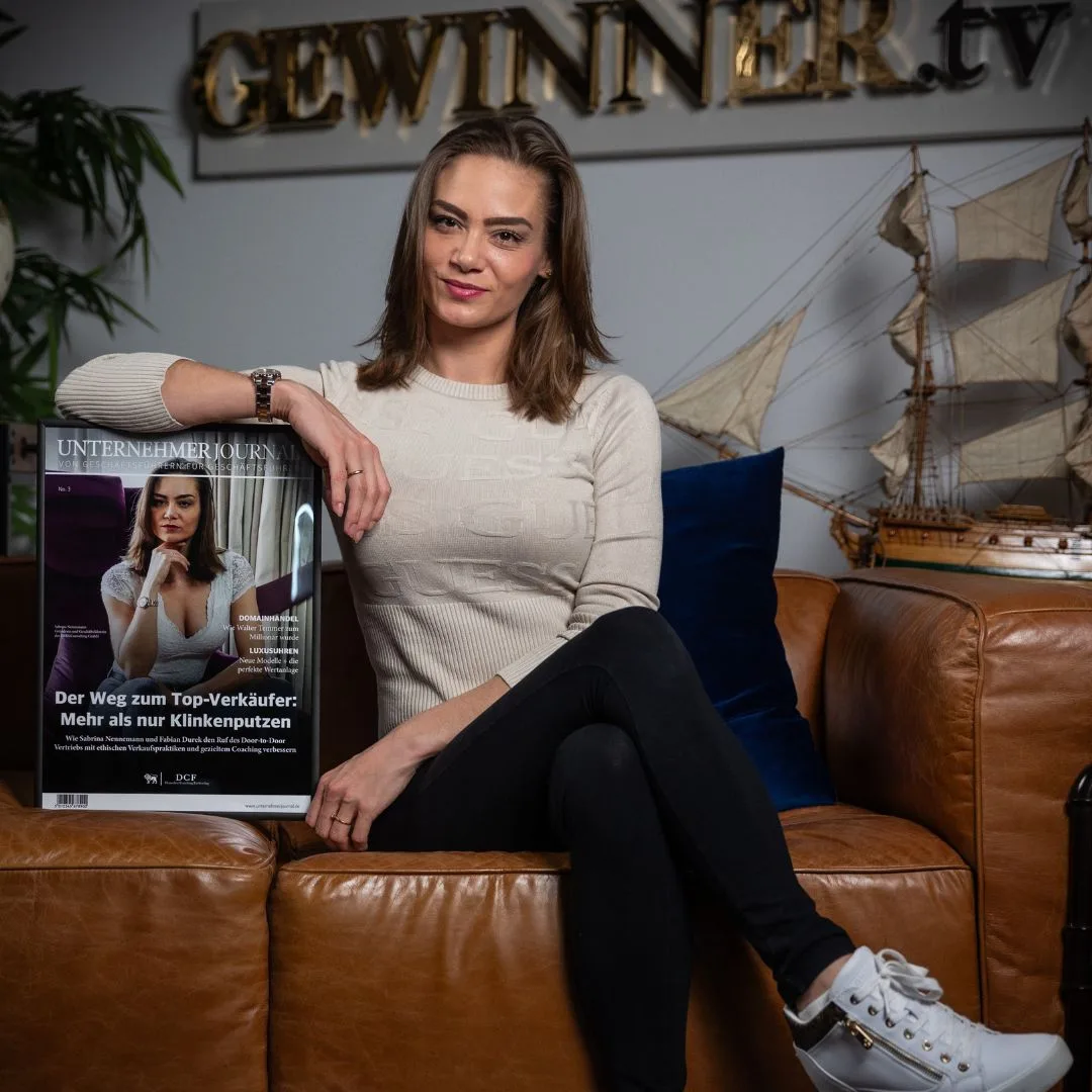 Frau sitzt auf Ledersofa mit Unternehmerjornal-Magazin, hält Artikel über Top-Verkäufer