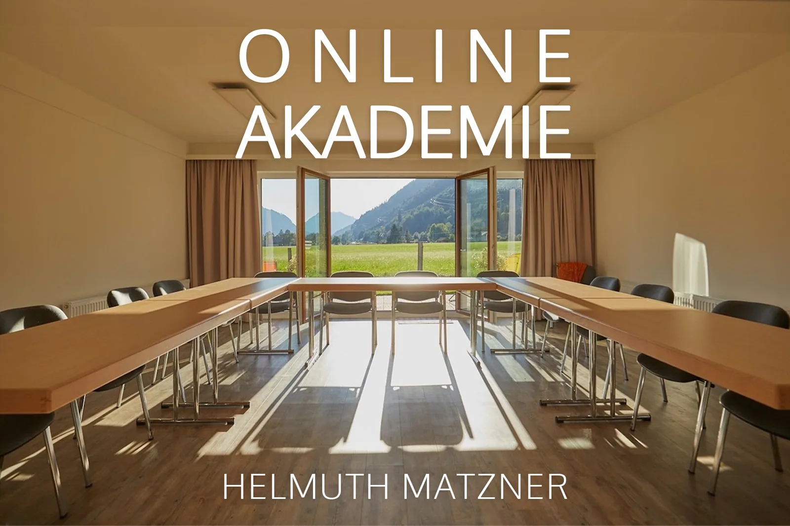 Tagungsraum mit großem Konferenztisch, Blick auf Alpine Berge, Text 'ONLINE AKADEMIE' und 'HELMUTH MATZNER'