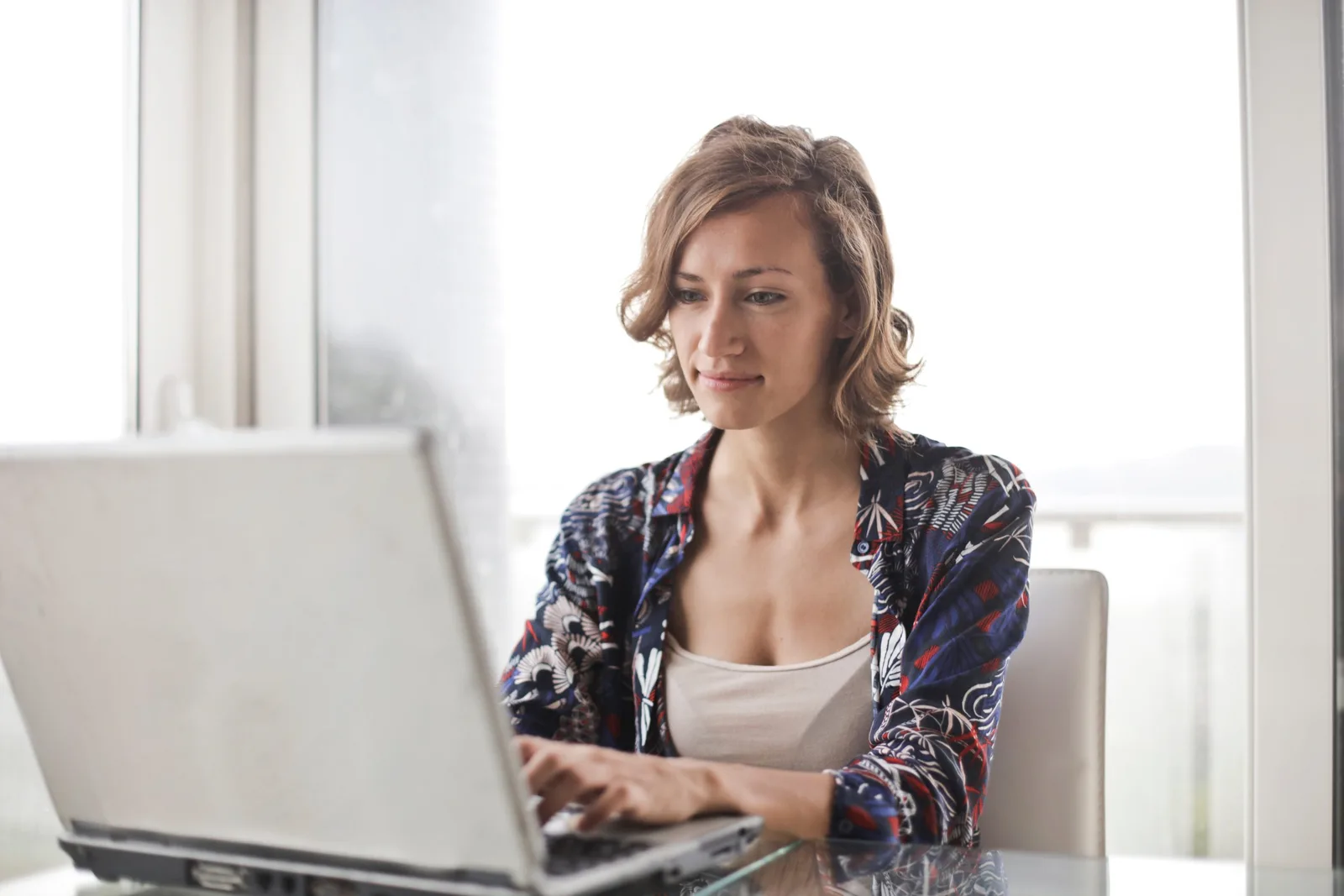 Das bewährte 7 Konten-Modell für Unternehmerinnen – Finanz-E-Book 3 Frau mit Laptop am Fenster, arbeitet konzentriert, helles Büro mit Tageslicht