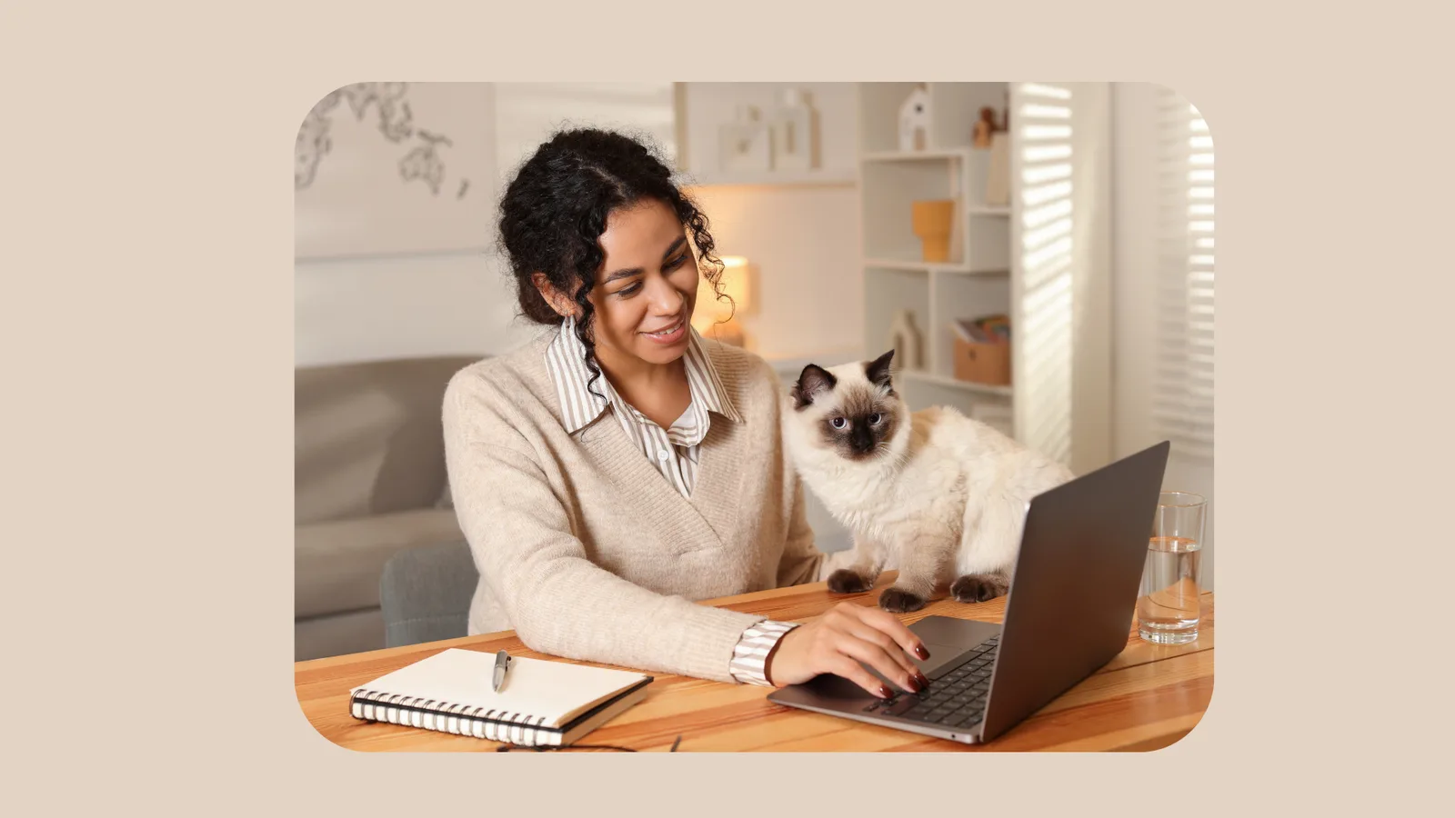Frau arbeitet am Laptop mit Katze auf dem Schreibtisch