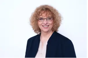 Das perfekte Verkaufsgespräch – Vertriebstraining als Videokurs 8 Porträt: Frau mit lockigem rötlichem Haar, Brille und dunklem Blazer