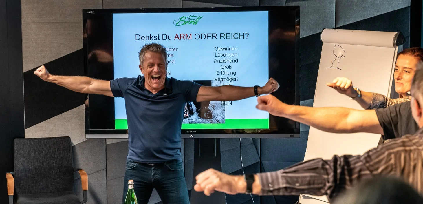 Andreas Enrico Brell präsentiert Live-Training mit Slide zur Frage Arm oder Reich