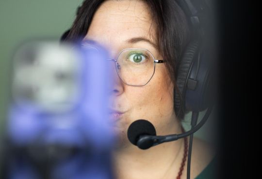 Marlen Kästner mit Headset und Brille, konzentriert bei Online-Session oder Aufnahme