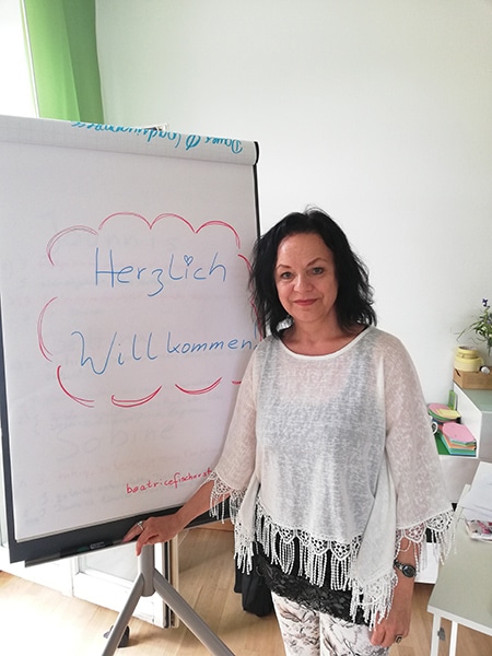 Beatrice Fischer-Stracke beim 1:1 Stimmtraining Coaching vor Flipchart mit Willkommensnachricht