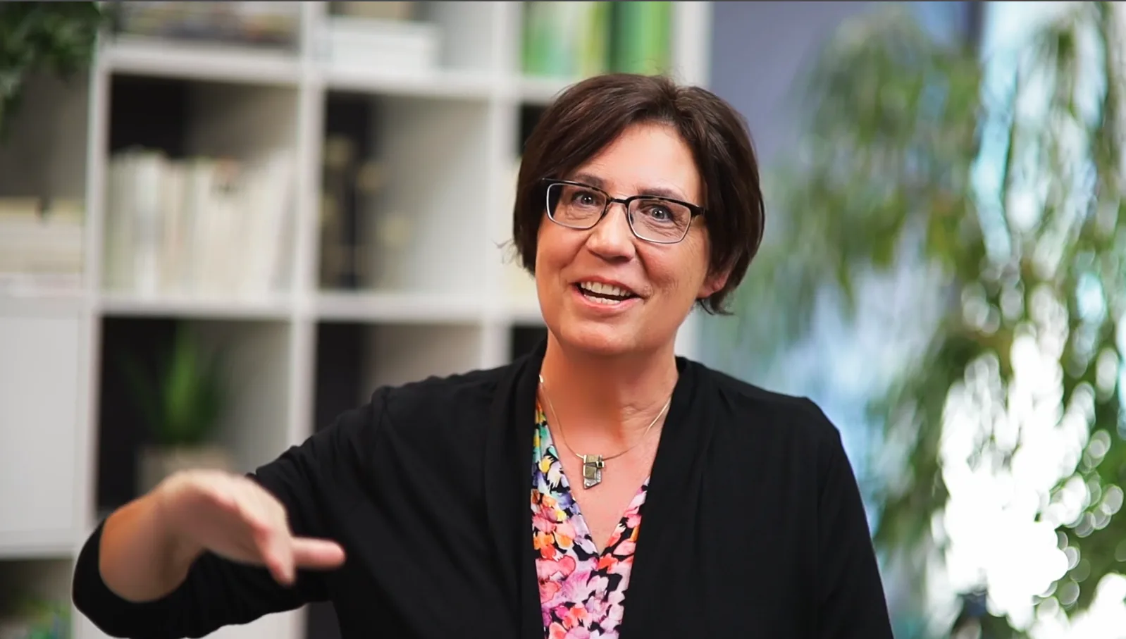 Vera Radnitz in Interview-Setting spricht zu Kamera mit Bücherregal und Pflanzen