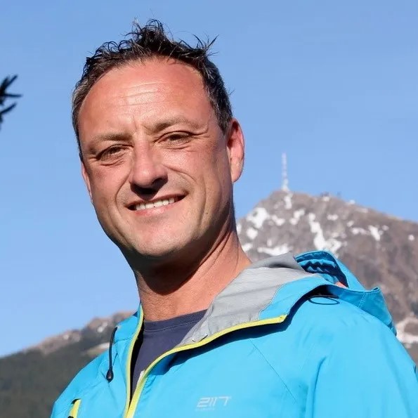 Anton Wieser Portrait, Mann in blauer Jacke vor Berglandschaft