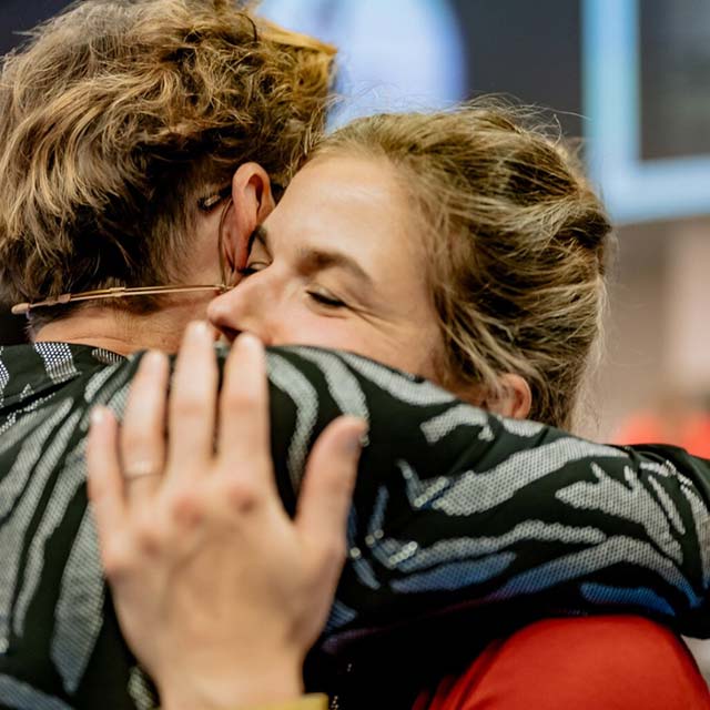 Zwei Personen umarmen sich eng, emotionaler Moment bei Kurs-Seminar