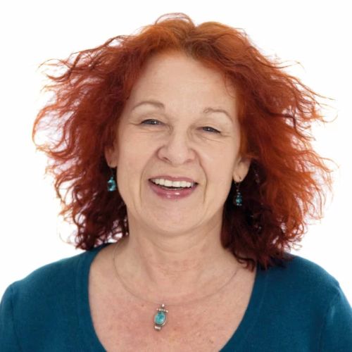 Porträt einer Frau mit rötlichem lockigem Haar, lachend vor weißem Hintergrund