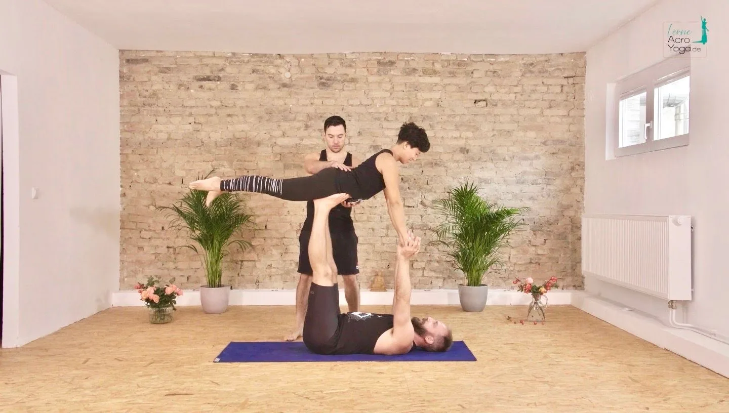 Die AcroYoga Uni – Mit Spiel & Spaß AcroYoga lernen 13 Zwei Männer führen AcroYoga-Partnerpose im Yoga-Studio mit Backsteinwand auf