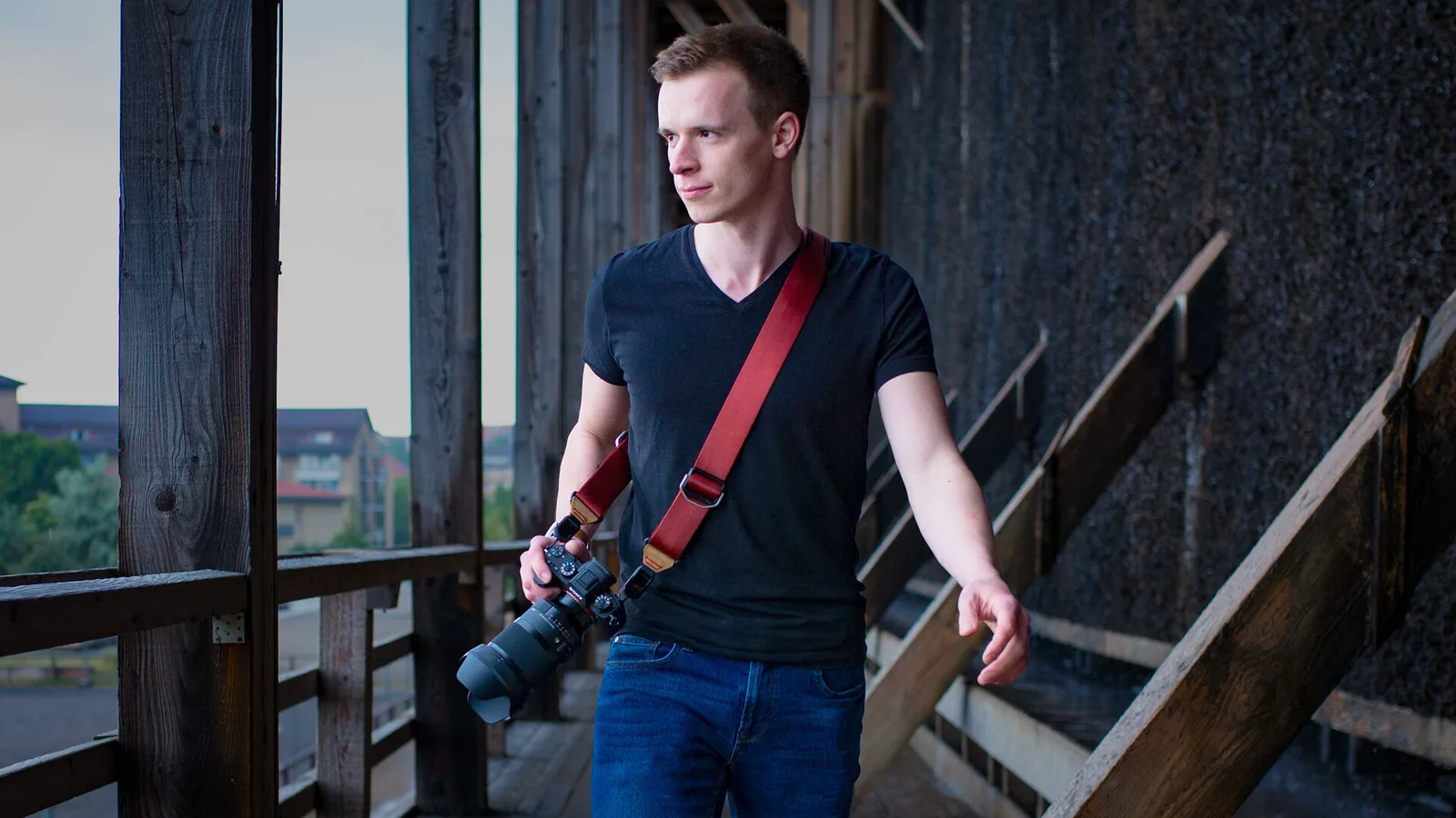 Fotograf mit Kamera auf Schulter an urbaner Industrielocation, Die Akademie Mentoring