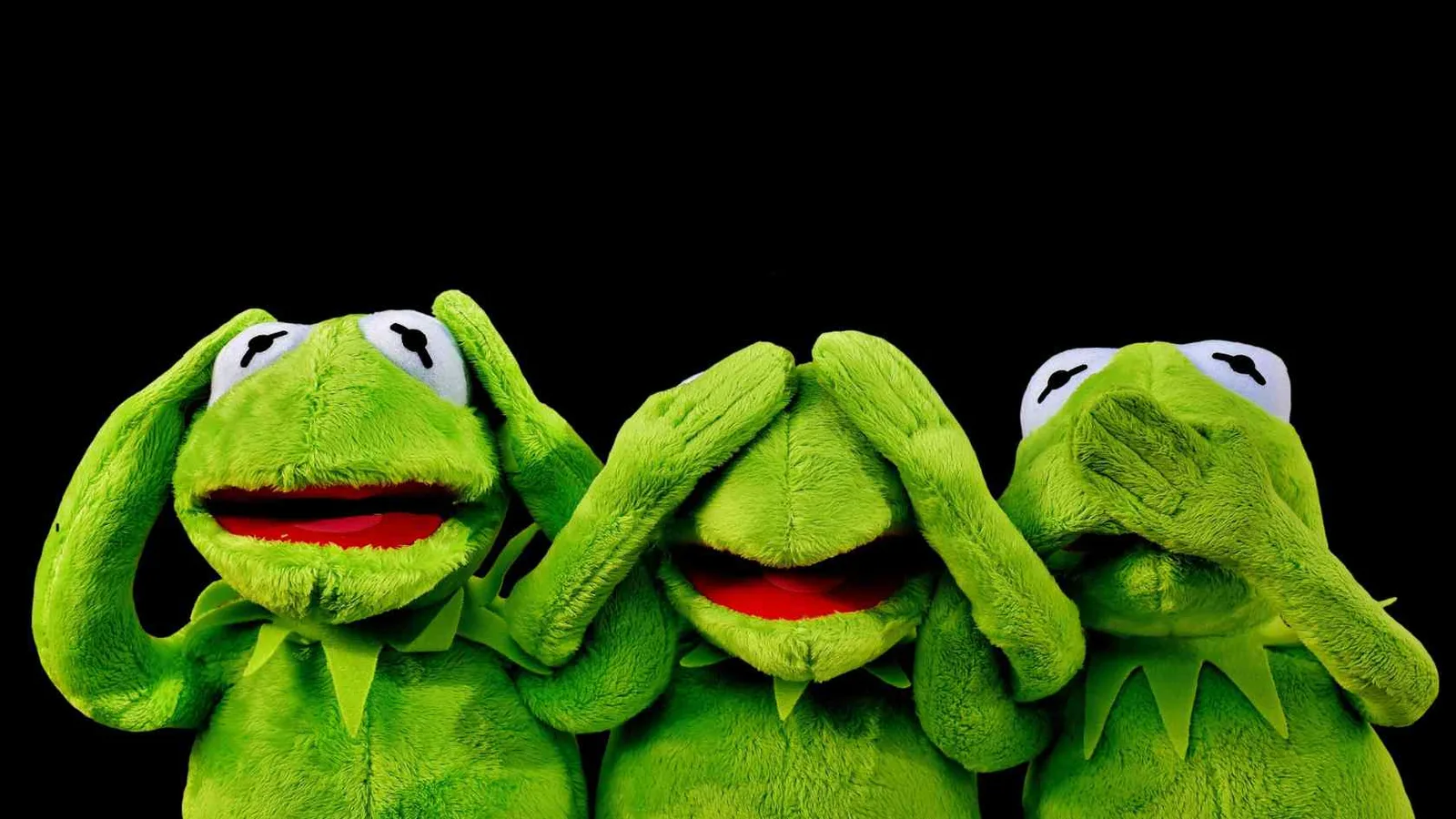Drei grüne Kermit-Puppen nebeneinander, jeweils mit Händen vor Augen, Ohren, Mund