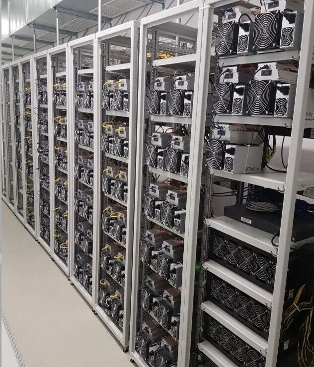 Mining-Farm mit mehreren Reihen von ASICs und Grafikkarten in industriellem Setting