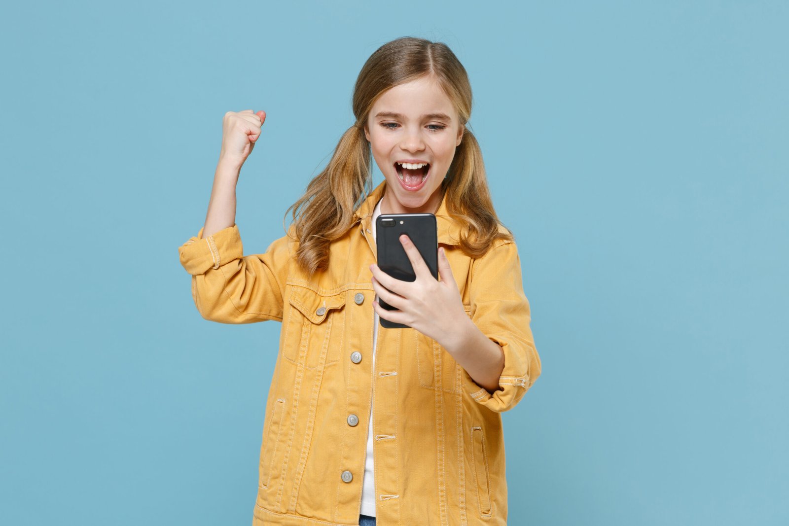 Digital-Club – Medienkompetenz-Live-Kurs für Kinder von Ben Fisch 2 Blonde Mädchen in gelbem Jeansjacke auf blauem Hintergrund, mit Handy und Siegesgest