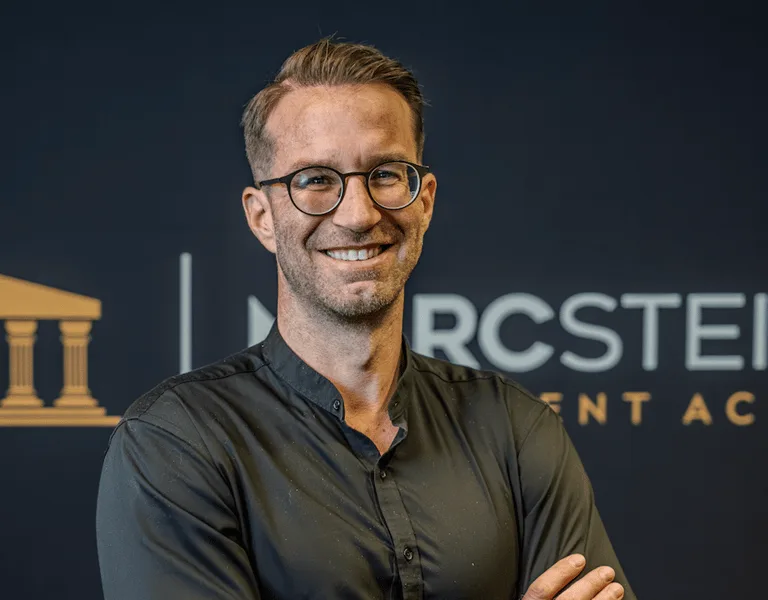 Marc Steiner, Autor des Kurses Digital sicher und geschützt, Portrait vor dunkelblauem Hintergrund