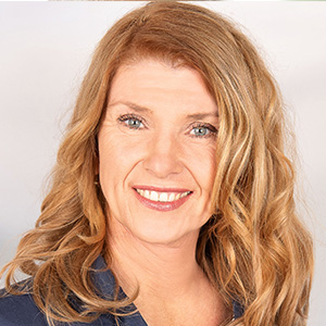 Gabi Schörk, Frau mit schulterlangem rötlich-blondem Haar und blauem Oberteil