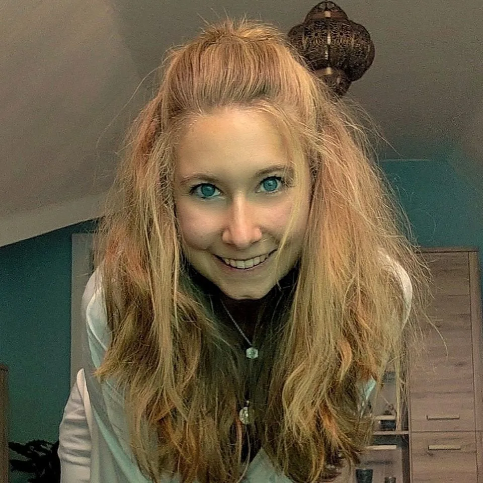 Monika Lautner mit langen hellblonden Haaren, blauem Blick und Dutt-Frisur, lächelnd