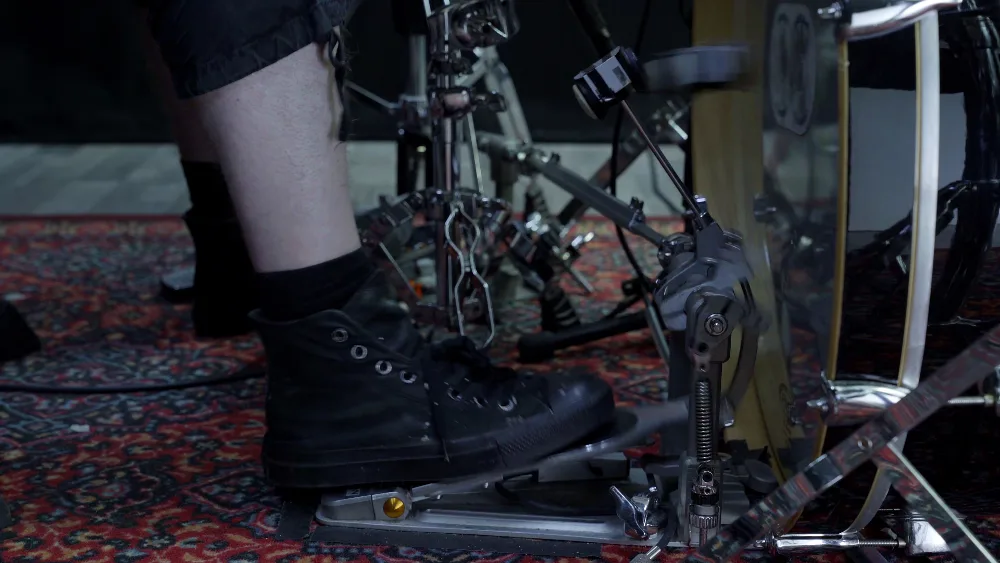 Nahaufnahme Füße: Doppelbassdrum-Pedal mit schwarzen Schuhen, Schlagzeug-Detailaufnahme