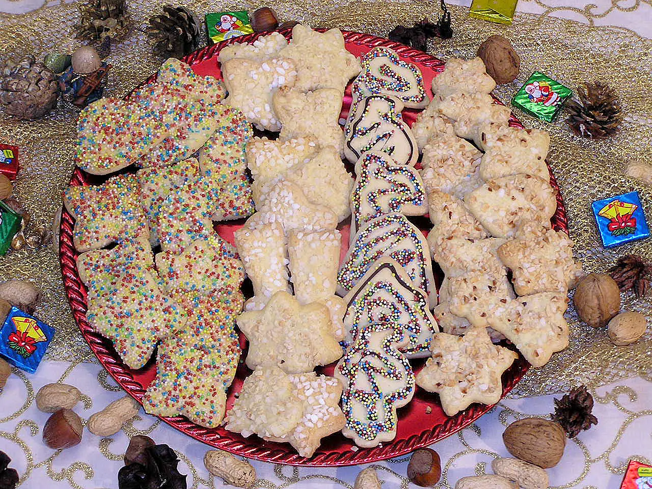 Weihnachtsplätzchen mit farbigen Zuckerperlen, Marmorier-Verzierungen und weißen Zuckerperlen