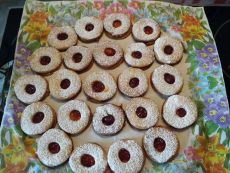 Backblech mit Plätzchen in Ringform mit Marmeladenfüllung und buntem Muster