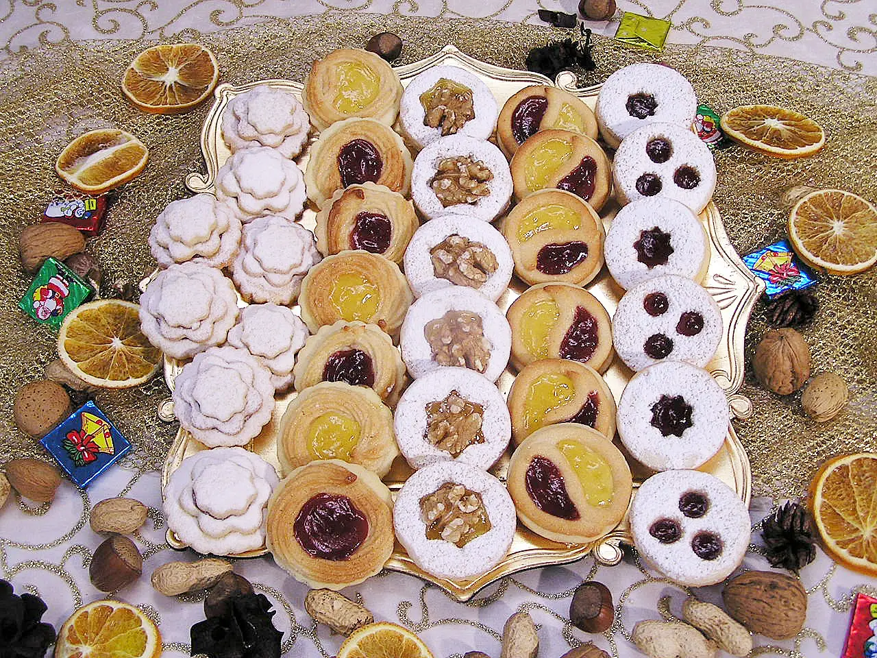 Hildabrötchen und Engelaugen-Gebäck in verschiedenen Varianten auf goldener Platte mit Weihnachtsdekoration