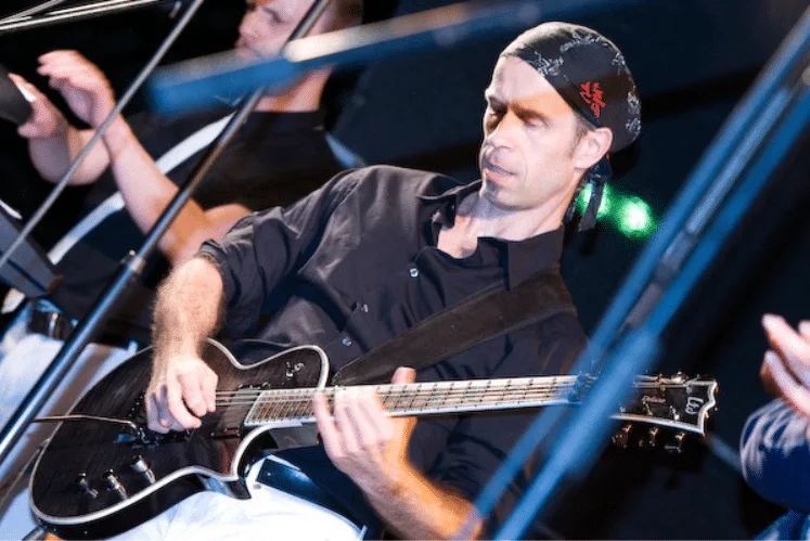 Andreas Vockrodt spielt E-Bass auf der Bühne mit blauer Beleuchtung