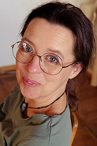 Porträtfoto von Linda Amadea Awe, weibliche Speakerin mit Brille und grünem Top