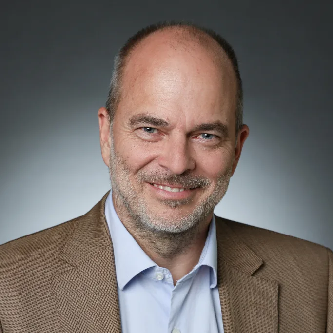 Porträt Dr. Ulrich Münch, Energie- und Strommarktexperte in braunem Sakko und Hemd