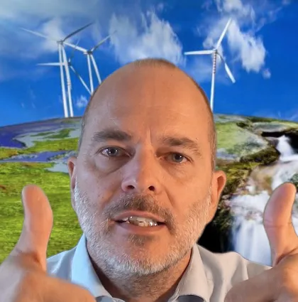 Dr. Ulrich Münch vor Landschaftshintergrund mit Windkraftanlagen, Videokurs Einführung Stromwirtschaft
