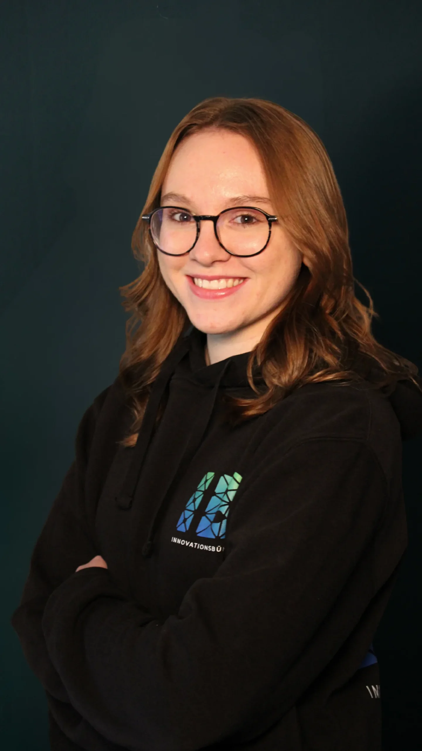 Einsteigerkurs Social Media & Reels von Vanessa Glaser 22 Porträt einer Frau mit Brille und rothaarig in schwarzer Kleidung mit Innovationsbühne-Logo