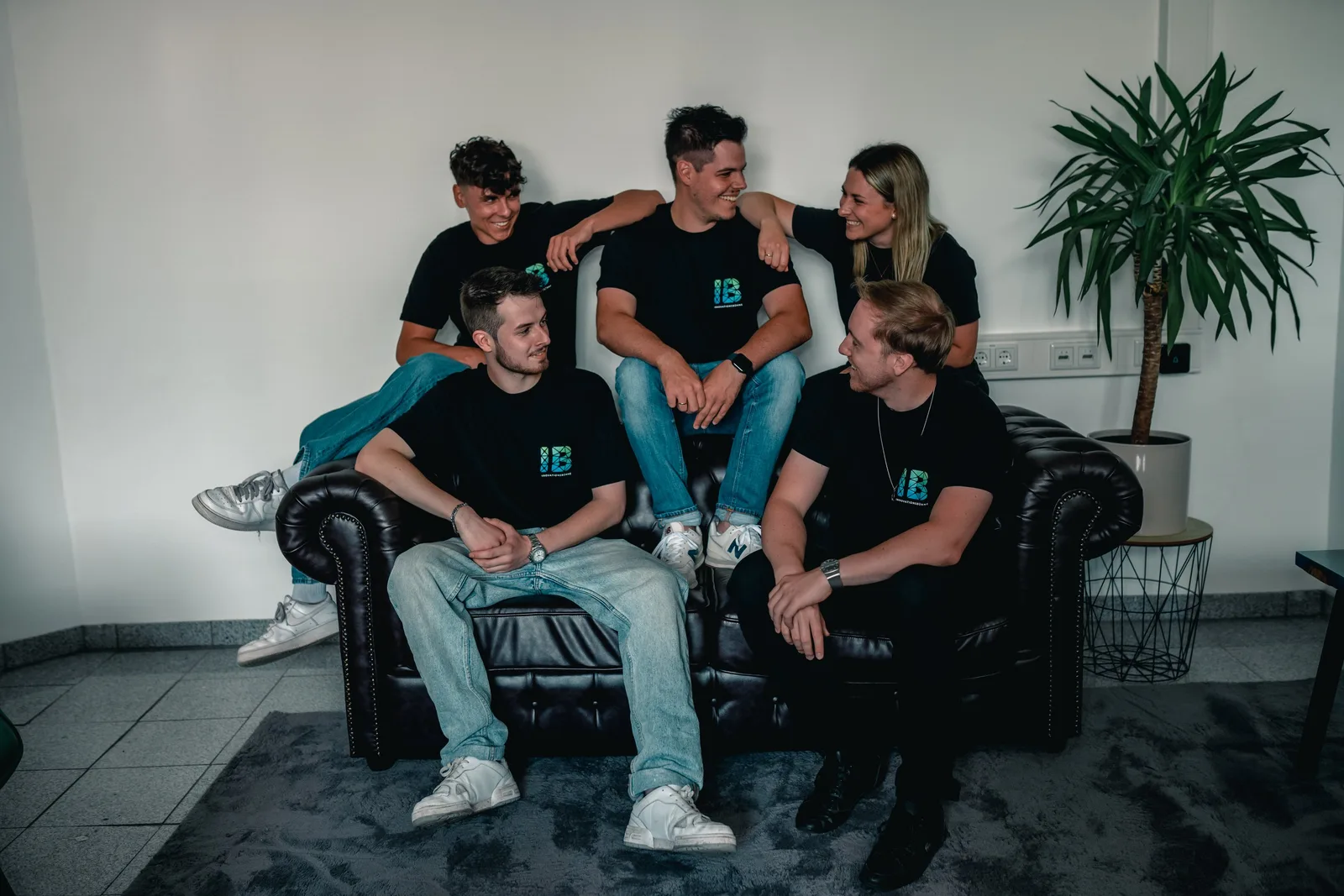 Einsteigerkurs Social Media & Reels von Vanessa Glaser 27 Gruppe von fünf jungen Menschen in schwarzen Innovationsbühne-Shirts auf Couch sitzend