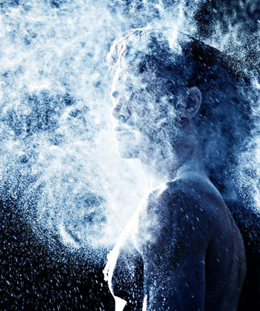 Frau von hinten mit Pulverwolke in blauem Licht, künstlerische Aufnahme
