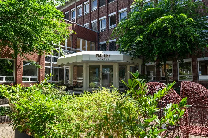 Factory Campus Eingang an der Erkrather Straße in Düsseldorf mit Grünflächen