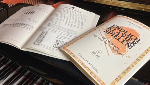 Notenblätter und Lehrbuch auf Klavier aufgeschlagen
