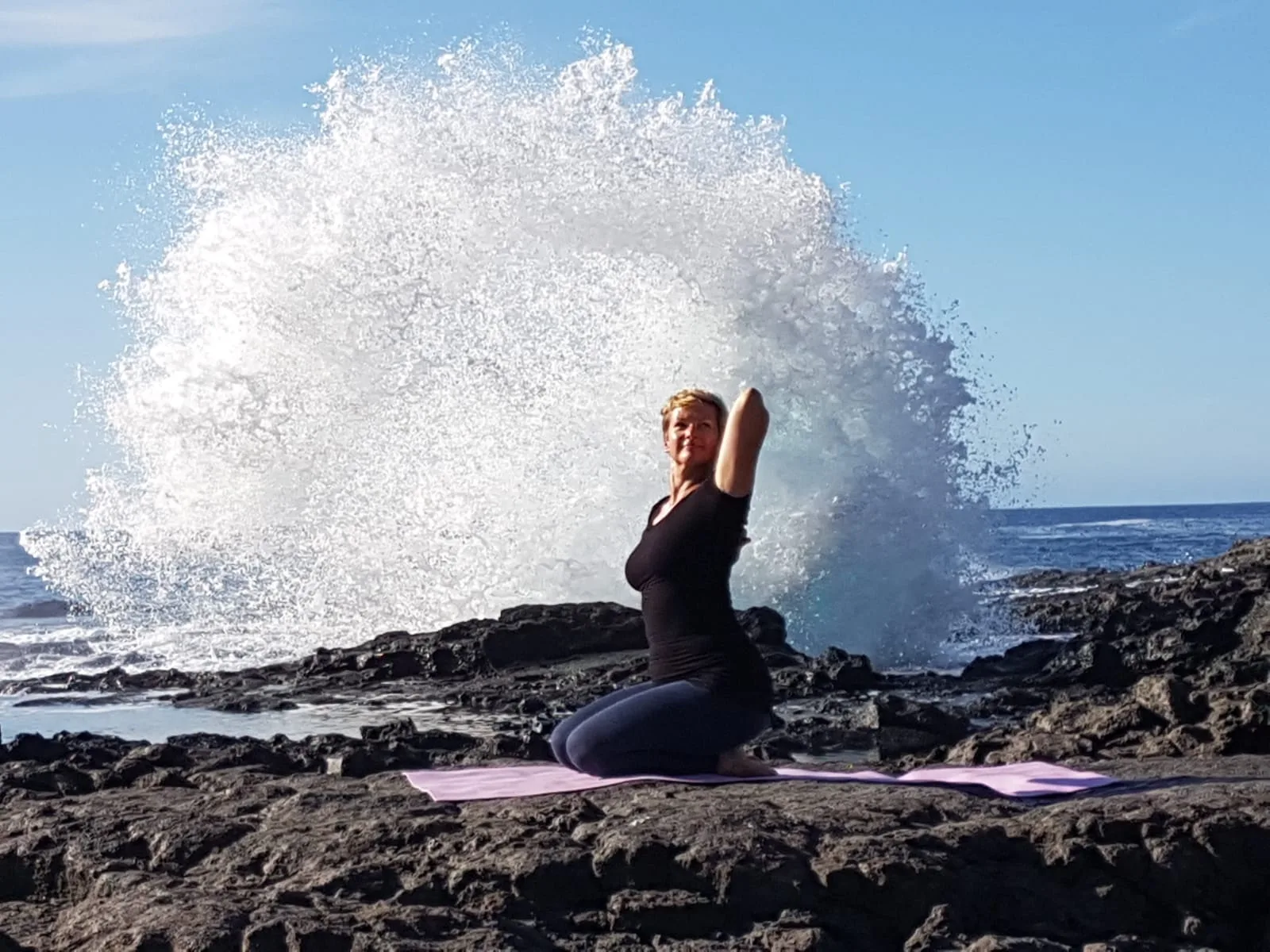 Endlich Migränefrei – Online-Coaching gegen Migräne von Anke Schneider 10 Anke Schneider in Yoga-Position auf Felsen mit großer Meereswelle im Hintergrund