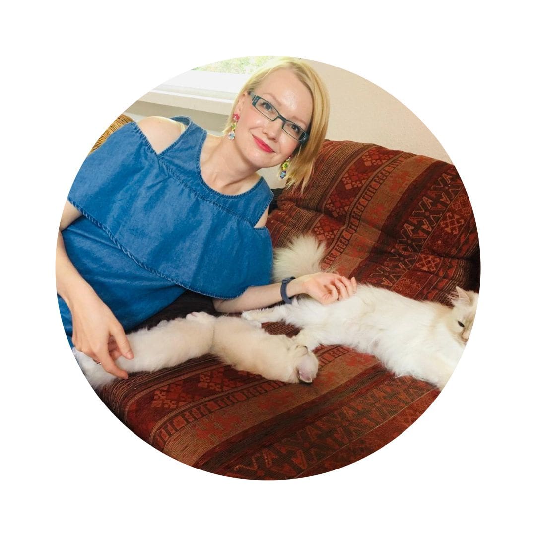 Endlich Migränefrei – Online-Coaching gegen Migräne von Anke Schneider 31 Frau mit braunem Haar und Brille sitzt auf Sofa mit weißer Katze