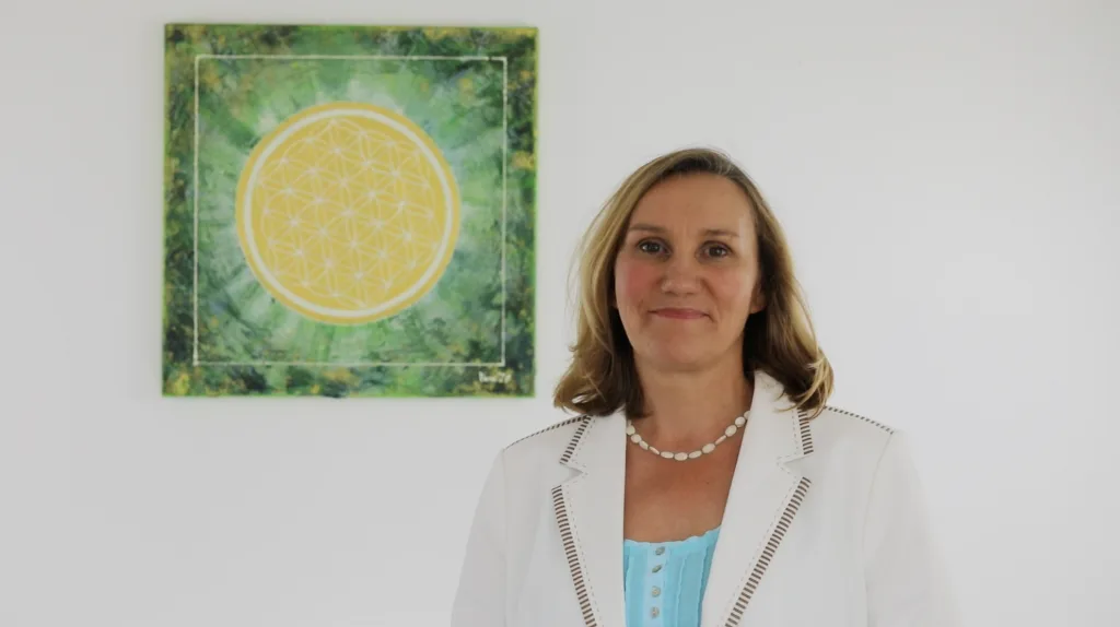 Energetic Colors – Farbenergie-Videokurs von Monika Baumgarth 7 Vera Mintken mit ihrem medialen Gemälde der Blume des Lebens im grünen Hintergrund